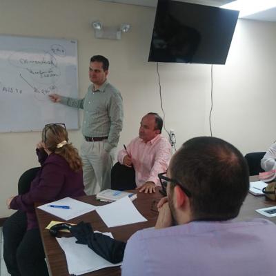 Hombre de pie explicando a sus compañeros de trabajo
