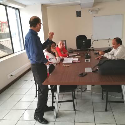Hombre de pie explicando a sus compañeros de trabajo
