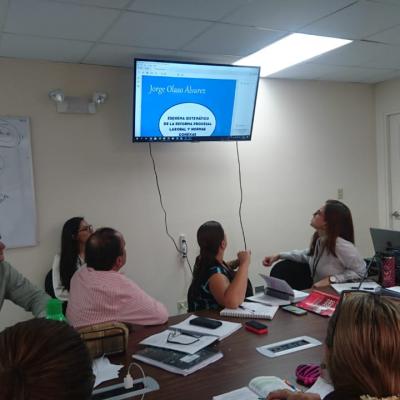 Personas en la sala de reuniones observando un monitor