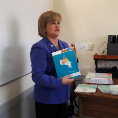 mujer  con cuaderno en sus manos y en su portada el mapa de Costa Rica