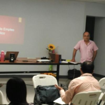 hombre de pie al frente con camisa color rosa