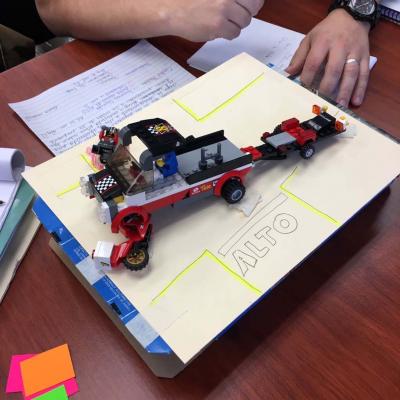maquete sobre un carro , encima de hoja blanca con palabra alto
