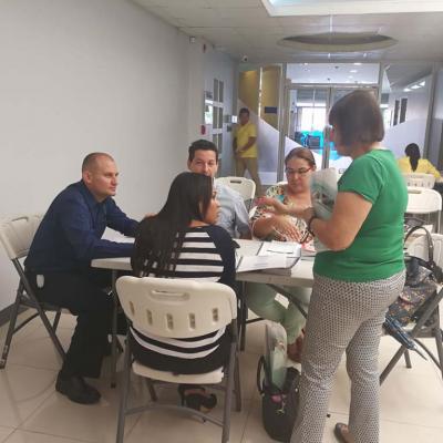 personas sentadas capacitándose y una mujer de pie
