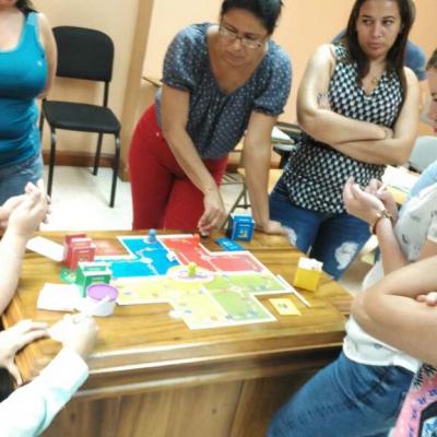 grupo de personas rodean mesa y ven una maqueta