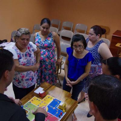 grupo de personas rodean mesa y ven una maqueta