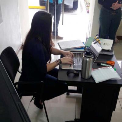 mujer sentada escribiendo en su computadora