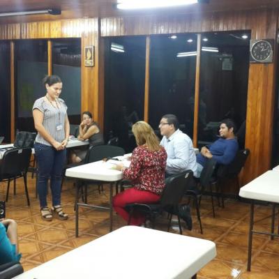 personas sentadas capacitándose y una mujer de pie