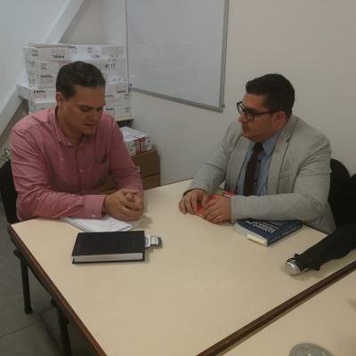 Dos hombres hablando en escritorio