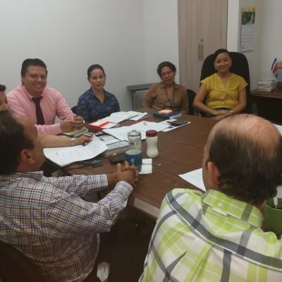 Personas reunidas en mesa de trabajo conversando