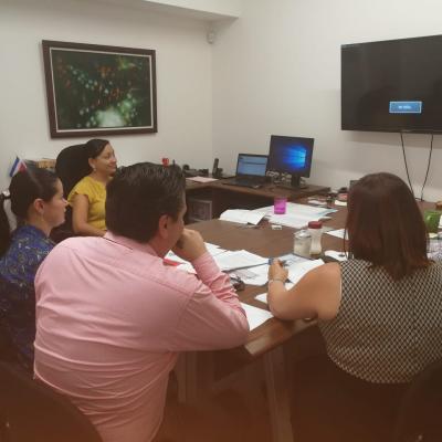 Personas reunidas en mesa de trabajo conversando