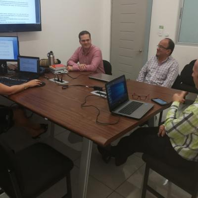 Personas reunidas en mesa de trabajo conversando