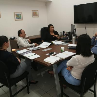 Personas reunidas en mesa de trabajo conversando
