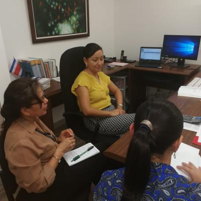 Personas reunidas en mesa de trabajo conversando