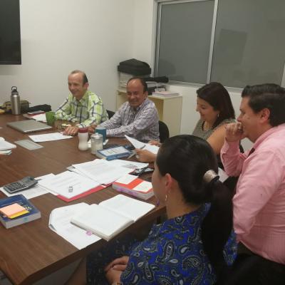 Personas reunidas en mesa de trabajo conversando